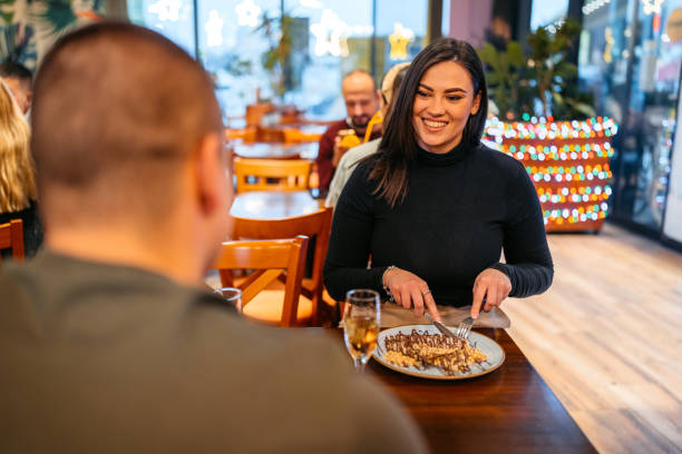 young couple eating belgian waffles and drinking champagne in a pub - waffle waffled belgian waffle food photos et images de collection