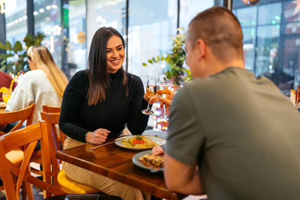 istock Young Couple Cheering With Champagne While Eating Belgian Waffles In A Pub 2083478733