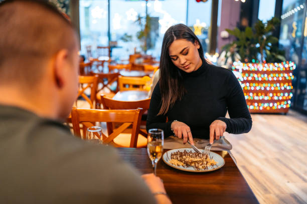 istock Young Couple Eating Belgian Waffles And Drinking Champagne In A Pub 2083481864