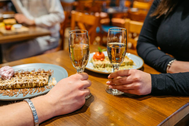 młoda para je belgijskie gofry i pije szampana w pubie - waffle eating meal food and drink zdjęcia i obrazy z banku zdjęć