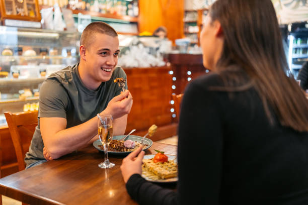 młoda para je belgijskie gofry i pije szampana w pubie - waffle eating meal food and drink zdjęcia i obrazy z banku zdjęć