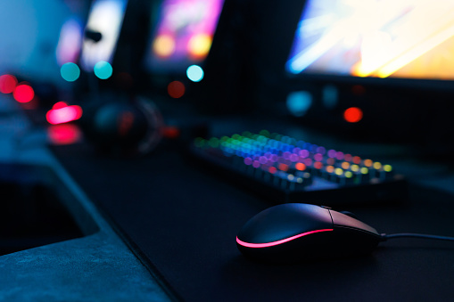 Computer mouse, keyboard, neon-illuminated headphones for esports, concept of a professional game