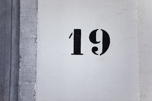 Weathered grunge square metal enameled plate of number of street address with number 121