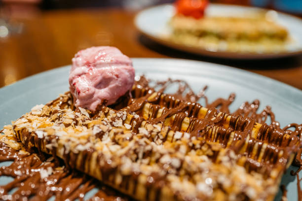 Belgian waffle with ice cream on a table in a pub. Close-up.