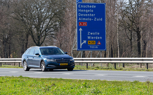 Netherlands, Overijssel, Twente, Wierden, March 19th 2023, side/front view close-up of a Dutch blue 2020 Skoda 3rd generation Superb station wagon diesel driving on the N36 at Wierden, the Superb has been made by Czech car manufacturer Škoda Auto since 2001, the N36 is a 36 kilometer long highway from Wierden to Ommen