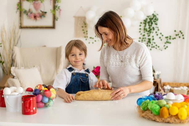 istock Happy children, siblings, coloring eggs for Easter at home, sunny room 2083527785