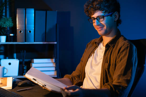 istock Young businessman reading design thinking on paper for new project. Gusher. 2083539566