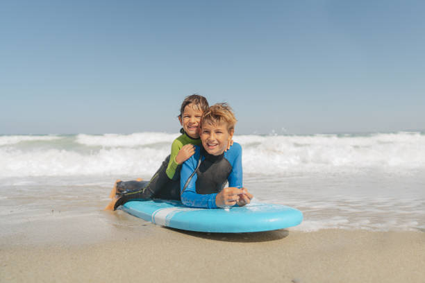istock First surfing lessons from an older brother 2083546654