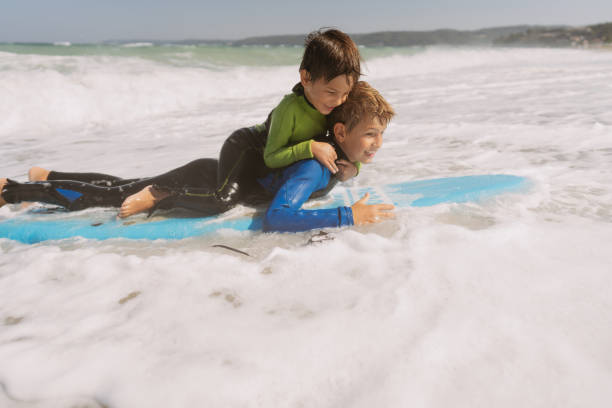 istock First surfing lessons from an older brother 2083547719