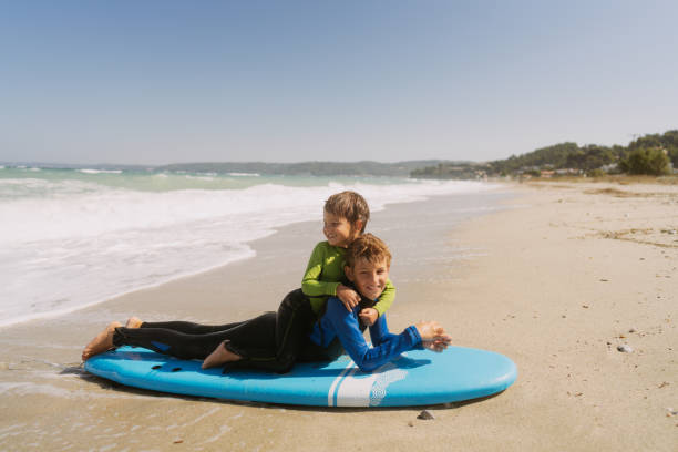 istock First surfing lessons from an older brother 2083547720