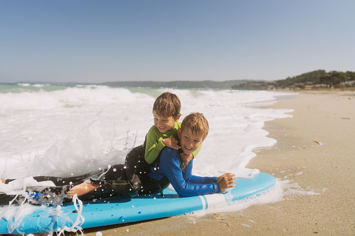 Photo of two young boys on the surfboard