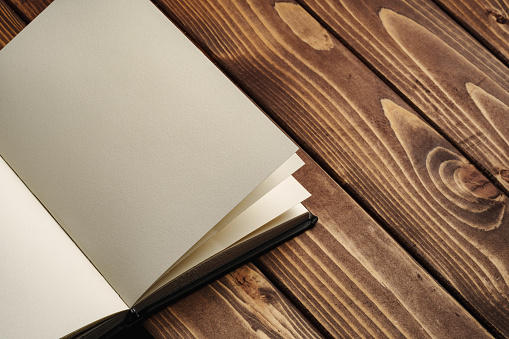 Blank notepad on a brown wooden surface close up