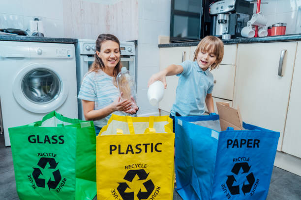 istock Mother is teaching kid how to recycle help the boy aware environmental importance - mom educates son sort garbage into different bins on kitchen. Family sorting garbage at home. Concept of recycling. 2083559219