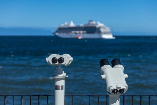 Observation binoculars with cruise ship and Patagonian landscape in background, 2024
