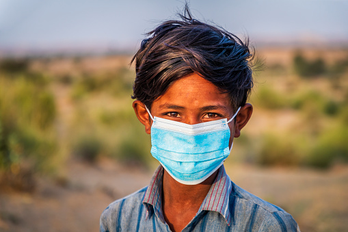 Portrait of Indian teenage boy wearing a face mask- desert village, Thar Desert, Rajasthan, India.