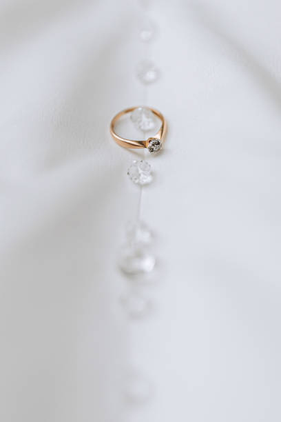 golden women's ring with a precious stone on a white background - couple gold pair vertical - fotografias e filmes do acervo
