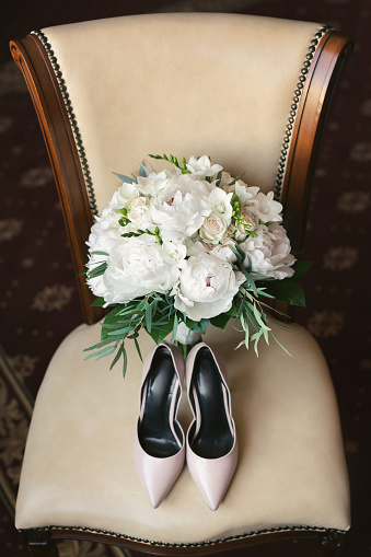 Wedding bouquet, the bride's shoes on the chair.