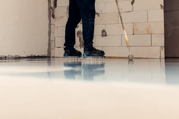 istock A construction worker apply grey epoxy resin in an industrial hall 2083613898