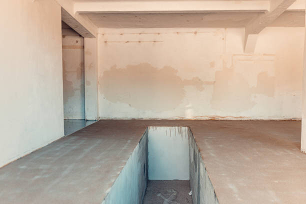 A construction worker apply grey epoxy resin in an industrial hall