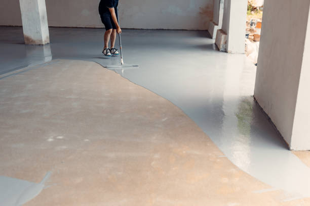 istock A construction worker apply grey epoxy resin in an industrial hall 2083616557