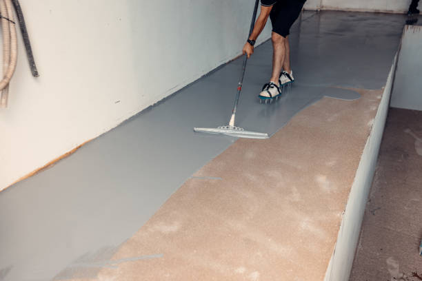 istock A construction worker apply grey epoxy resin in an industrial hall 2083617669