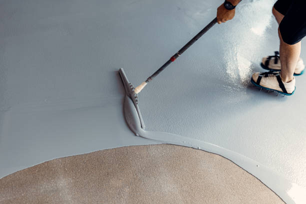 istock A construction worker apply grey epoxy resin in an industrial hall 2083624582