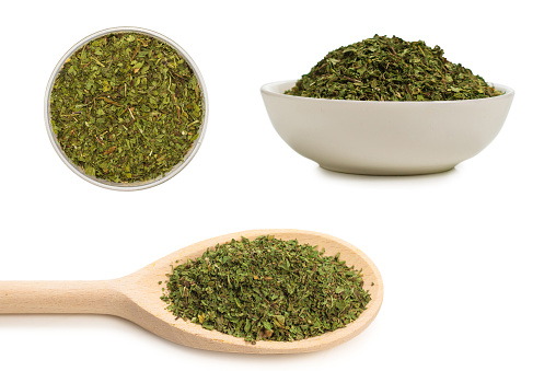 Dried green mint in a bowl isolated on white background.