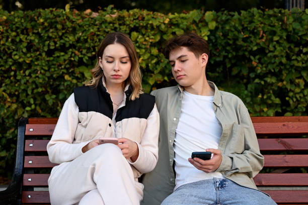 istock A curious and jealous guy peeks at his girlfriend's phone 2083637212