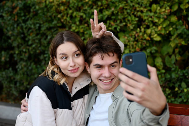 istock Two young people take a selfie on the phone and make funny faces while hanging out 2083637224