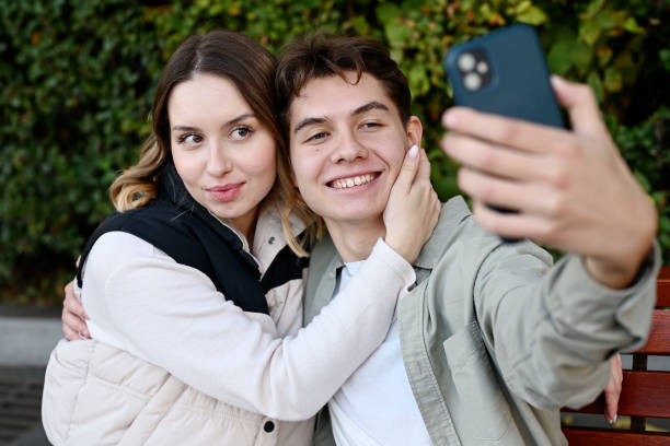 istock young people take a selfie on their phone while hanging out in the park 2083637499