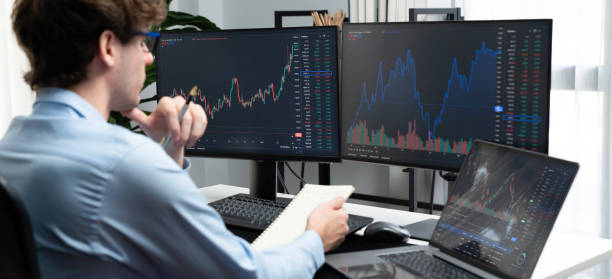 istock Working trader looking on laptop on screens, holding notepad and pen. Gusher. 2083641403