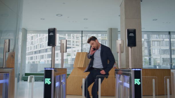 istock Office worker running entrance office with automatic gates talking cellphone. 2083647856
