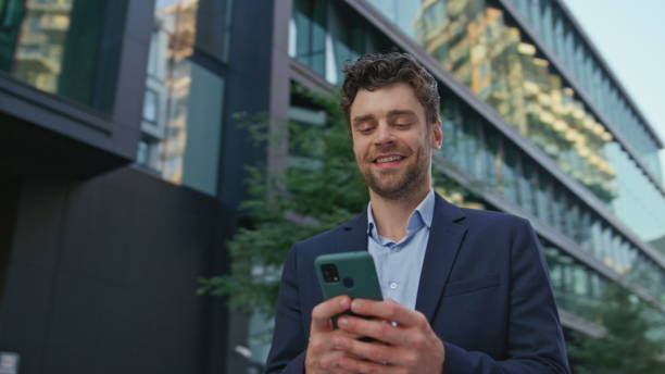 istock Attractive manager texting cellphone at urban district close up. Man messaging 2083655274