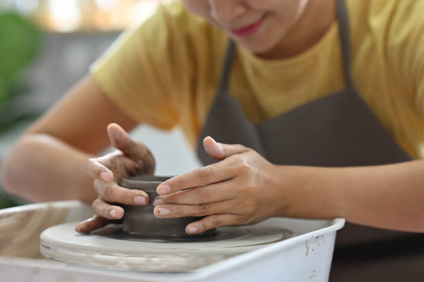 istock Close up and cropped image of Woman's hands making ceramic cup on potter's wheel. 2083689834