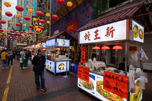 Hong Kong - March 14, 2024 : People visit food stalls at Temple Street Market in Hong Kong.