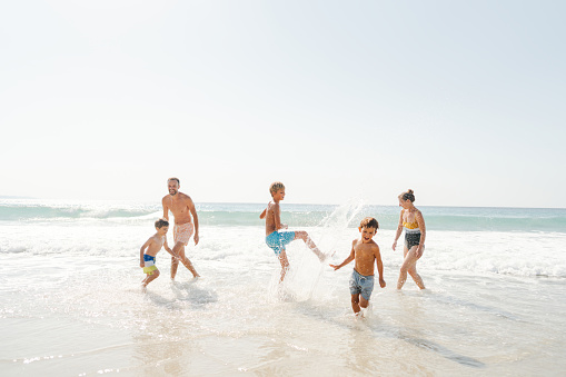 Photo of a family with three boys, spending quality time together on the beach