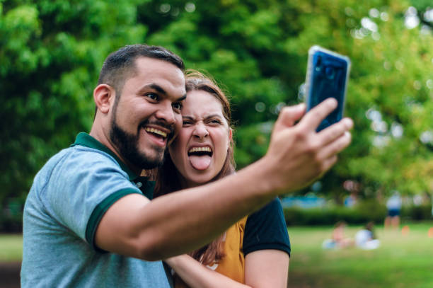 młoda latynoska para robi sobie selfie z zabawnymi twarzami i wysuniętym językiem - contreras zdjęcia i obrazy z banku zdjęć