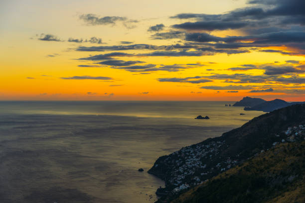 Aerial idyllic view of of beautiful hills and the sea in bight yellow sun rays of sunset in South Italy