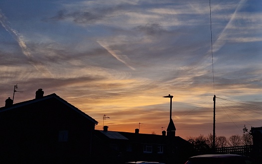 The amazing morning light in English countryside in Hertfordshire UK with contrails from aircraft above, 14th March 2024