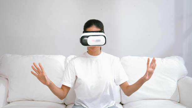 istock Young woman using virtual reality VR goggle at home for vivancy online shopping experience. The virtual reality VR innovation optimized for female digital entertainment lifestyle. 2083765006
