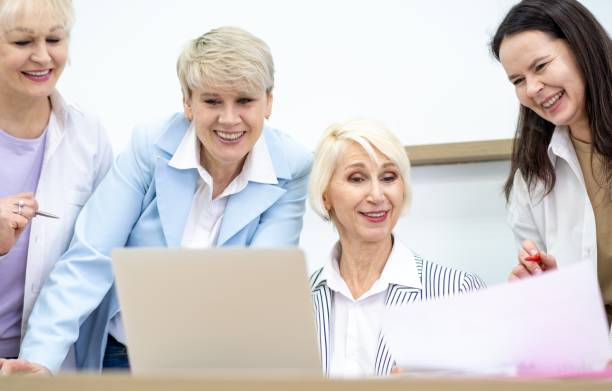istock Four happy businesswomen discussing a project while looking at a laptop. 2083795546