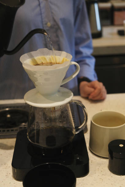 istock Unrecognizable Barista Pouring Hot Water Into Coffee Drip Filter 2083797746