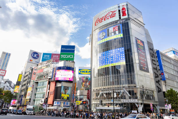 Shibuya Ward, Toyko Tokyo, Japan - October 6, 2023: People crowding the streets of Shibuya, Tokyo, near Shibuya Crossing, with towering skyscrapers in the background. low angle street japan stock pictures, royalty-free photos & images