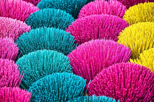 Multi-coloured incense sticks for sale in Hue, Vietnam. Hue is famous for the traditional hand made incense sticks that can be found in a variety of scents and colors, displayed on market stalls.
