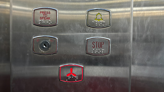 The silver elevator has a number of buttons on it.