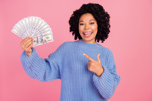 Photo of adorable cool lady dressed knitted sweater showing finger money fan isolated pink color background.