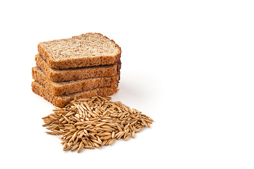 Slices of grain bread and wheat grains on a white isolated background. Healthy food concept.