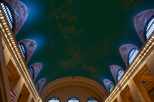 Grand Central station, New York City, USA. The ceiling has gold astrological  or constellation symbols on a green background.