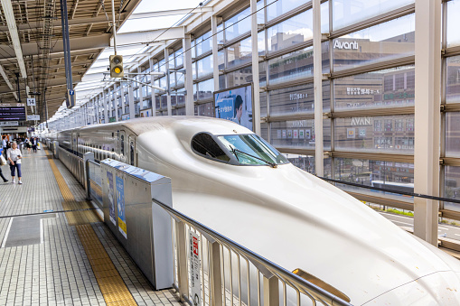 Osaka, Japan - October 11, 2023:  The Shinkansen high speed  bullet train  station platform at the Kyoto railway train station in Kyoto, Japan with e train in view.