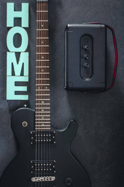 istock Electric guitar and amplifier on a dark background with decorative word Home. 2083878742